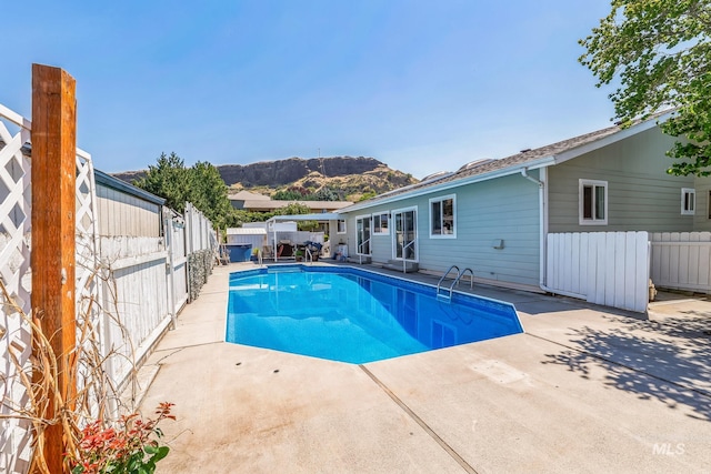 view of pool featuring a mountain view and a patio