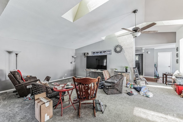 carpeted living room with ceiling fan and lofted ceiling with skylight