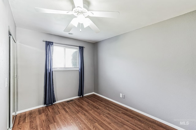 spare room featuring dark hardwood / wood-style floors and ceiling fan