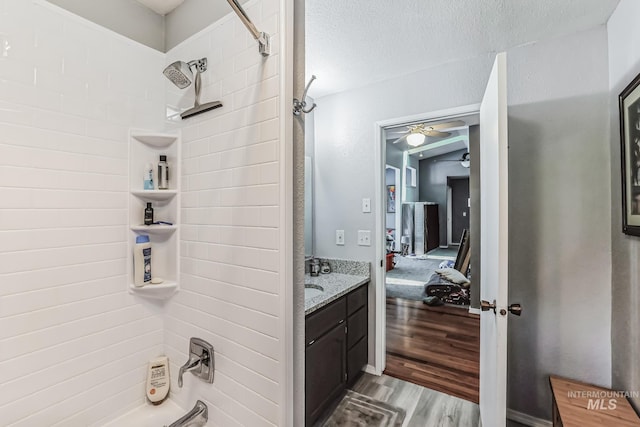 bathroom featuring vanity,  shower combination, wood-type flooring, and a textured ceiling