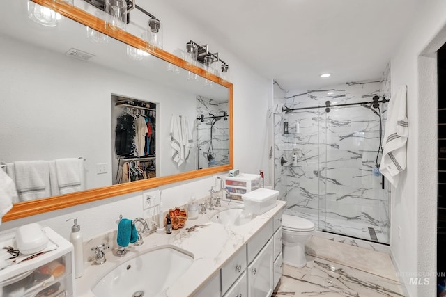 bathroom with vanity, toilet, and a shower with door