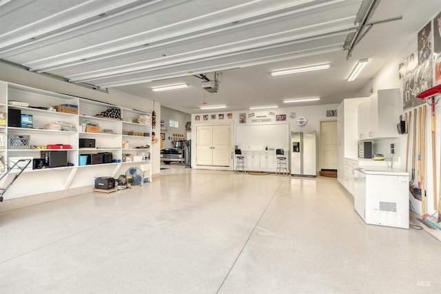 garage with a garage door opener, stainless steel fridge, and fridge