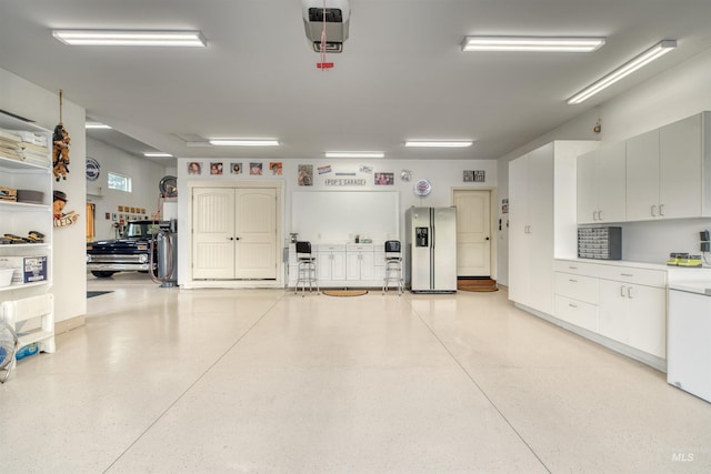 garage with washer / dryer and stainless steel fridge