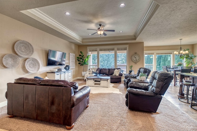 living room with crown molding, a textured ceiling, and a raised ceiling