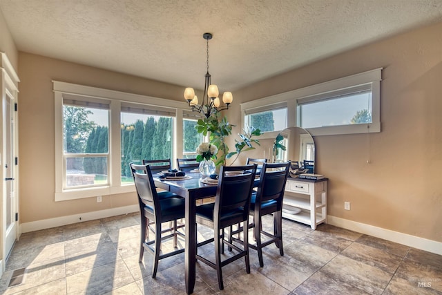 dining room featuring a textured ceiling and a chandelier