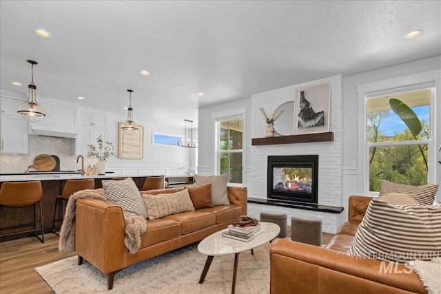 8701 W Suttle Lake Dr, Boise, ID 83714 - living area featuring plenty of natural light, recessed lighting, light wood-style floors, a fireplace, and a chandelier