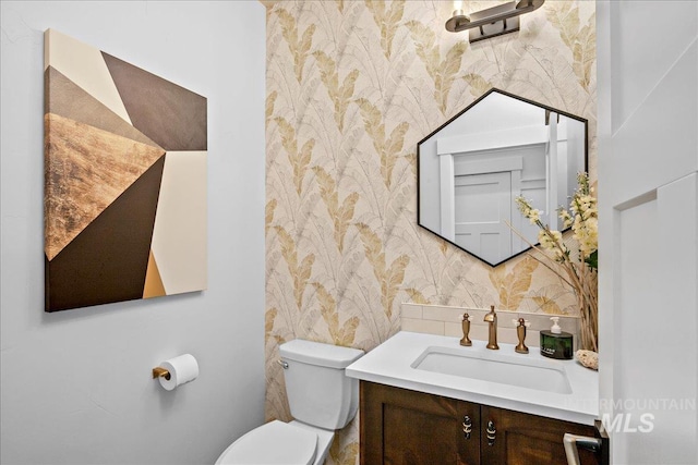 8701 W Suttle Lake Dr, Boise, ID 83714 - bathroom with wallpapered walls, toilet, vanity, and backsplash