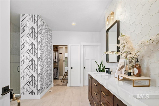 8701 W Suttle Lake Dr, Boise, ID 83714 - bathroom featuring double vanity, a spacious closet, a shower stall, and decorative backsplash