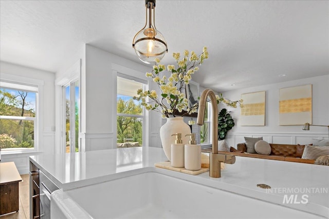 8701 W Suttle Lake Dr, Boise, ID 83714 - detailed view of a sink, a decorative wall, decorative light fixtures, a textured ceiling, and light countertops