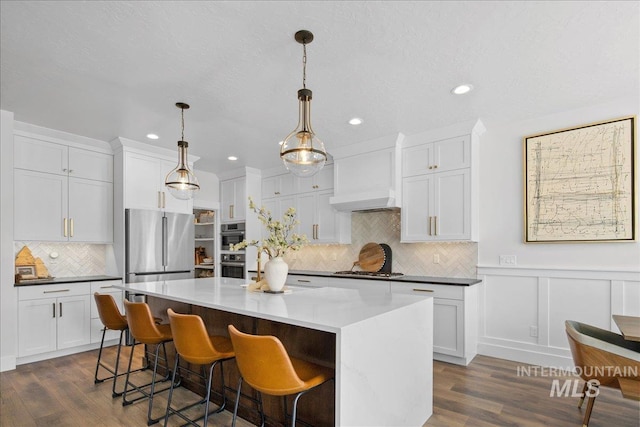 8701 W Suttle Lake Dr, Boise, ID 83714 - kitchen with dark wood-type flooring, tasteful backsplash, a kitchen island, white cabinetry, and recessed lighting