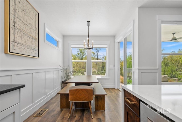 8701 W Suttle Lake Dr, Boise, ID 83714 - dining area with a decorative wall, a chandelier, dark wood-type flooring, and a wainscoted wall