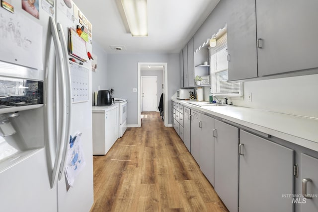 kitchen featuring white appliances, gray cabinetry, and light countertops