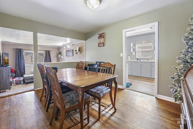 dining area with baseboards and hardwood / wood-style floors