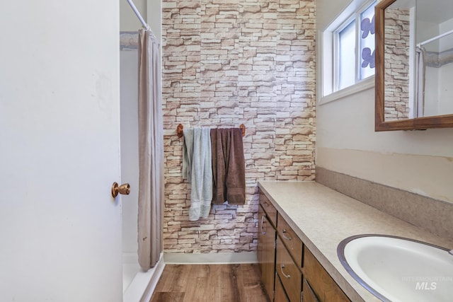 bathroom with a shower with shower curtain, wood finished floors, and vanity