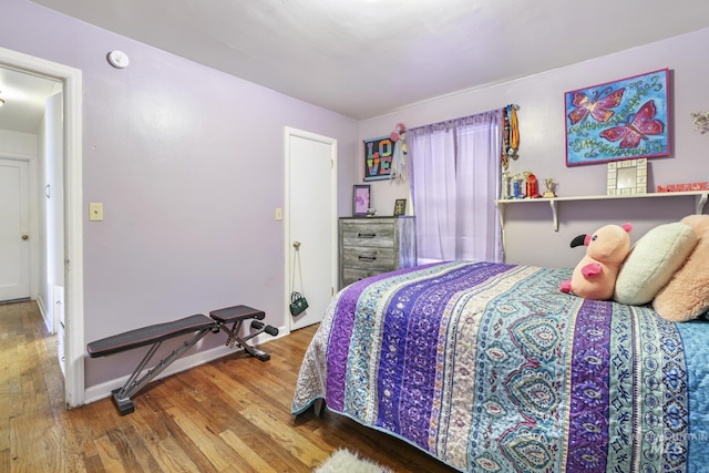 bedroom with baseboards and wood finished floors