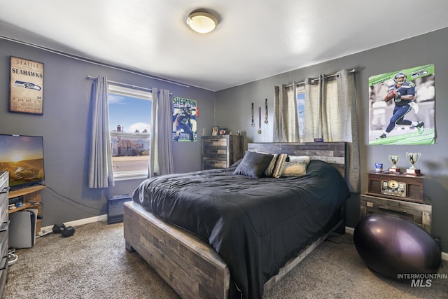 carpeted bedroom featuring baseboards and multiple windows