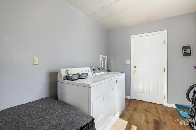 laundry room featuring washer and dryer, baseboards, wood finished floors, and laundry area