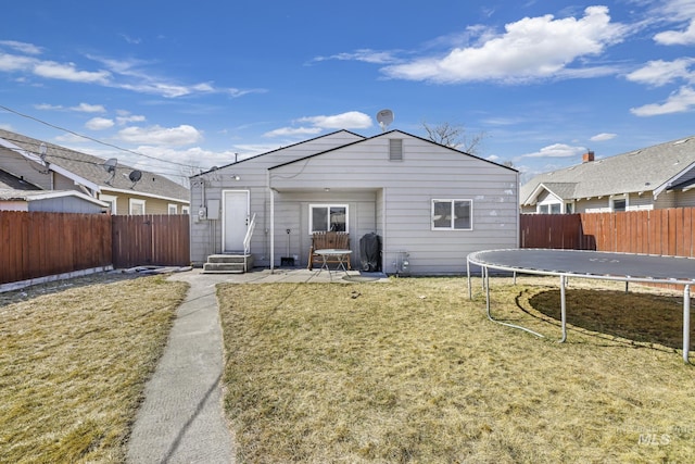 back of house with a fenced backyard, a patio area, entry steps, and a trampoline