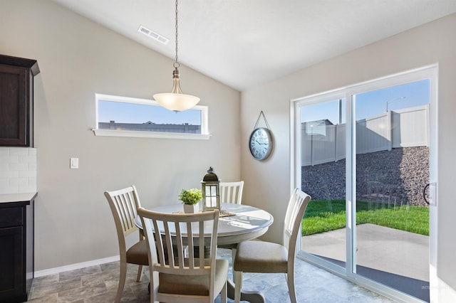 17785 N Onaway Ave, Nampa, ID 83687 - dining area with vaulted ceiling, plenty of natural light, baseboards, and light stone finish floors