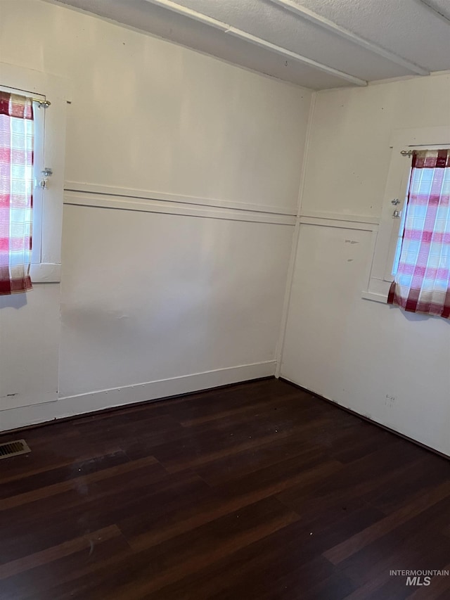 spare room with dark hardwood / wood-style flooring