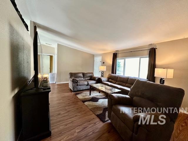 living room featuring lofted ceiling and dark hardwood / wood-style floors