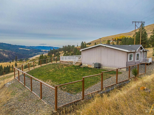 view of yard featuring a mountain view, central AC unit, and a rural view