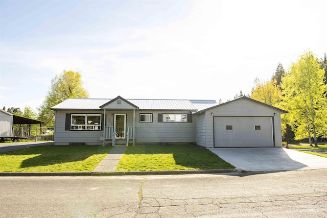 view of front of property with an attached garage, concrete driveway, a front yard, and metal roof