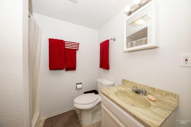 full bathroom with toilet, vanity, and baseboards