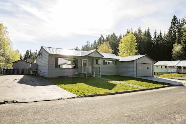 ranch-style house featuring concrete driveway, a garage, and metal roof