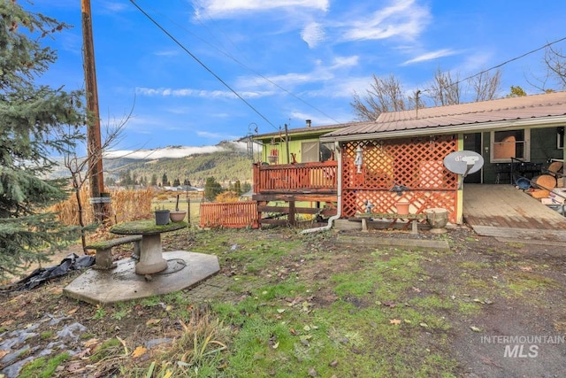 view of yard with a deck with mountain view