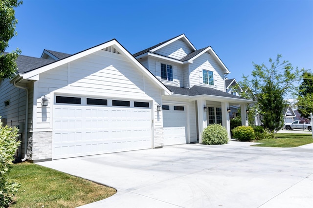 1946 W Windswept, Meridian, ID 83646 - view of front facade with concrete driveway, stone siding, a garage, and a shingled roof