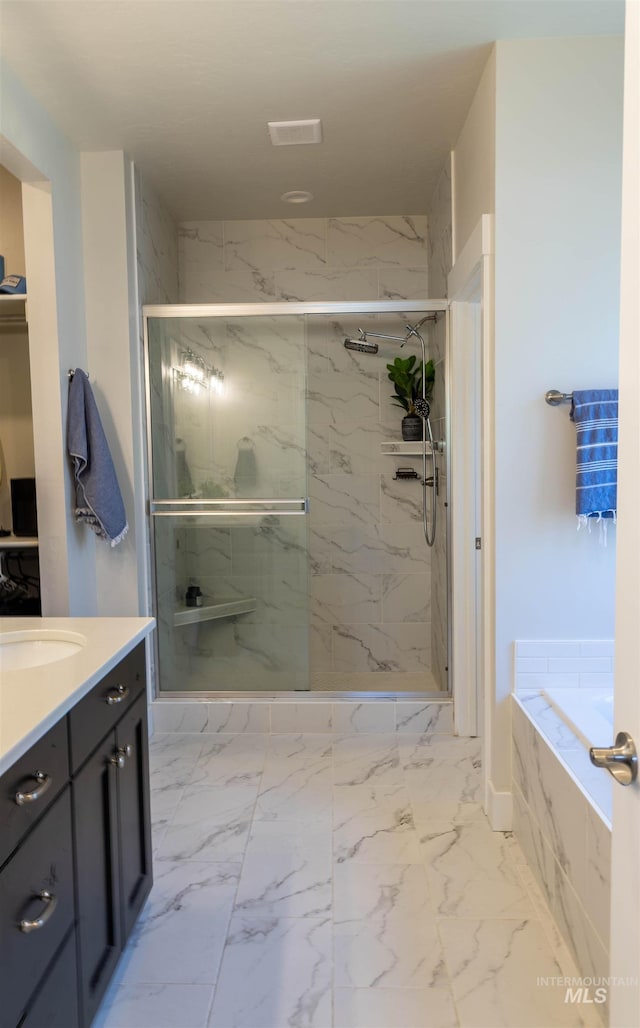 1946 W Windswept, Meridian, ID 83646 - full bath featuring marble look tiles, a marble finish shower, vanity, and a bath