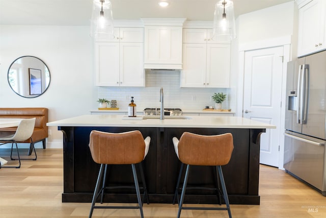 1946 W Windswept, Meridian, ID 83646 - kitchen featuring stainless steel fridge, a breakfast bar area, a center island with sink, light countertops, and recessed lighting
