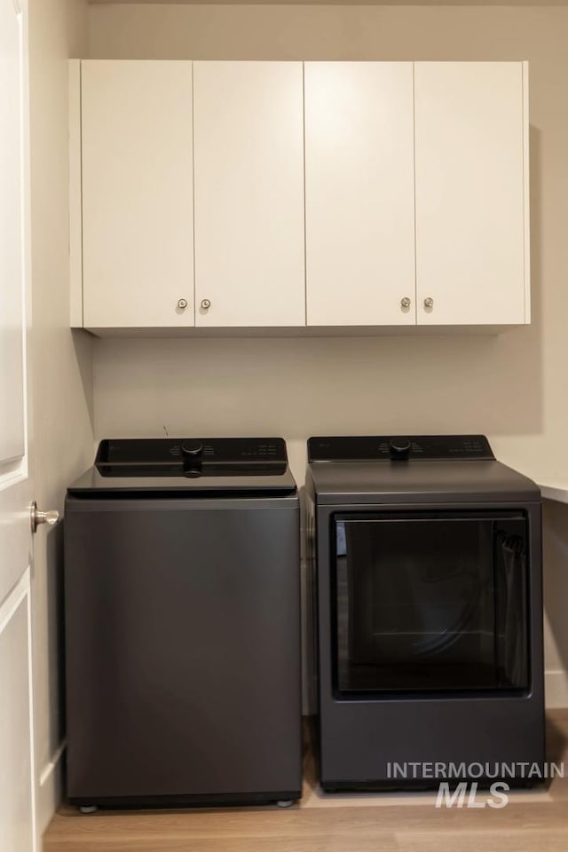 1946 W Windswept, Meridian, ID 83646 - washroom featuring washer and clothes dryer, wood finished floors, and cabinet space