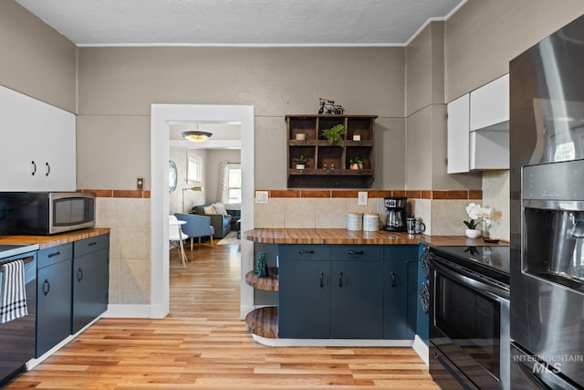 4705 W Franklin Rd, Boise, ID 83705 - kitchen with stainless steel appliances, open shelves, light wood-style floors, butcher block counters, and white cabinetry