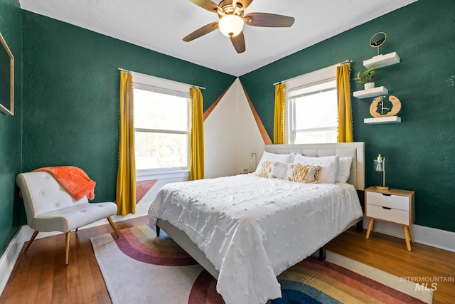 4705 W Franklin Rd, Boise, ID 83705 - bedroom featuring wood-type flooring, multiple windows, and a ceiling fan