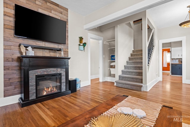 4705 W Franklin Rd, Boise, ID 83705 - unfurnished living room with stairs, wood finished floors, a stone fireplace, and built in features