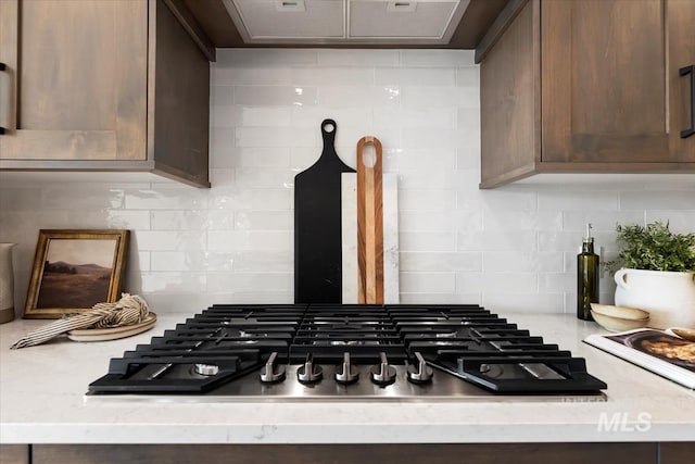 interior details featuring backsplash and stainless steel gas cooktop