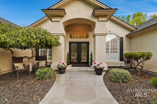 entrance to property featuring stucco siding and french doors