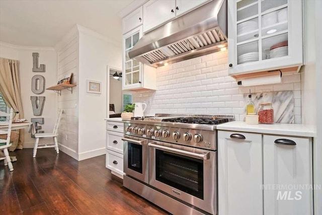 kitchen featuring white cabinets, range with two ovens, glass insert cabinets, range hood, and light countertops