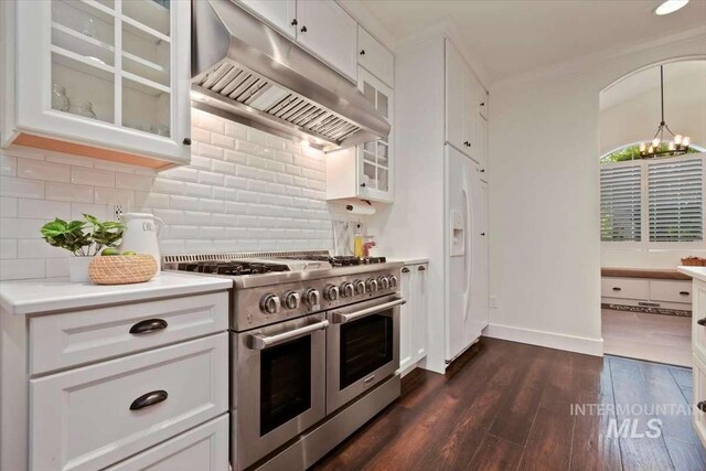 kitchen featuring range with two ovens, glass insert cabinets, ventilation hood, light countertops, and white cabinetry