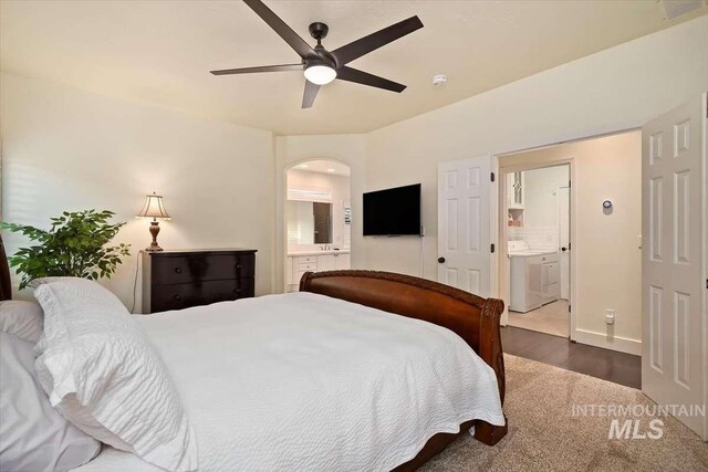 bedroom featuring dark wood-style floors, arched walkways, ceiling fan, and ensuite bathroom