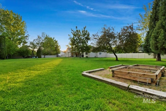 view of yard with a vegetable garden and fence