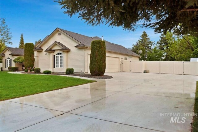 single story home featuring a garage, fence, driveway, a gate, and a front yard