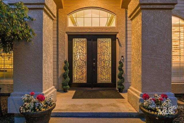 property entrance featuring french doors and stucco siding