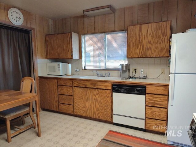 2738 Dixie Rd, Dixie, ID 83525 - kitchen with white appliances, a sink, light floors, decorative backsplash, and brown cabinetry