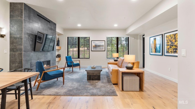 living room featuring light hardwood / wood-style floors and a tile fireplace