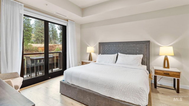 bedroom with access to outside and light hardwood / wood-style flooring