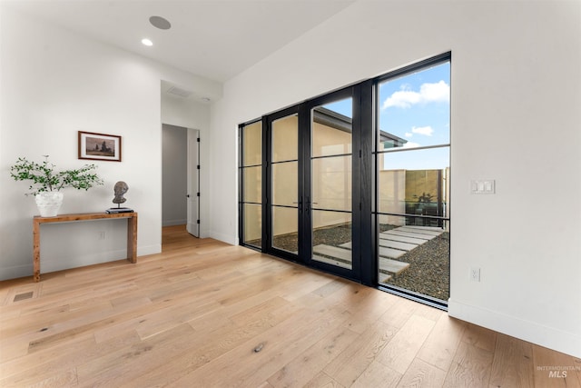 spare room with light wood-type flooring and french doors