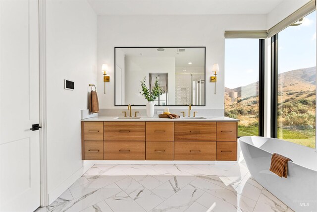 bathroom featuring independent shower and bath, vanity, a wealth of natural light, and a mountain view